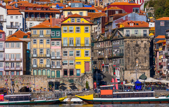 Colorful houses of Porto Ribeira, traditional facades, old multi-colored houses with red roof tiles on the embankment in the city of Porto, Portugal
