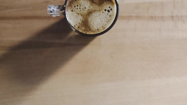 A top view of a freshly brewed coffee, very creamy. The image moves vertically.