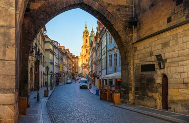 Fotobehang Prague view of Mala Strana (Lesser Town of Prague) through the arch of the Malostransky tower of Charles Bridge. View of colorful old town in Prague taken from Charles bridge, Prague, Czech Republic © daliu