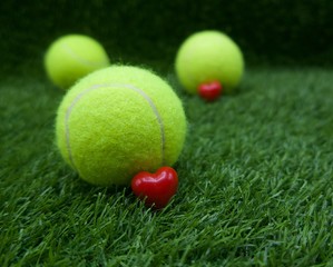 To tennis player with love shape and tennis ball on green grass