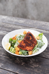 Close up on  a blackened salmon Caesar salad with space for text