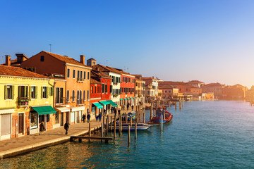 Murano glass making island, water canal, bridge, boat and traditional buildings. Venice or Venezia, Italy, Europe.