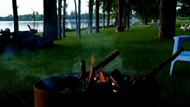 Crackling campfire in firepit near lakeshore in northern Minnesota on calm evening