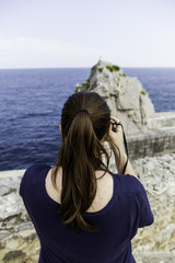 Fototapeta na wymiar Young woman making photos to the sea