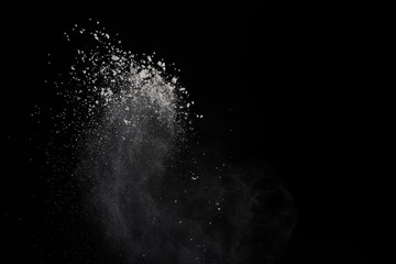 Explosion of colored powder isolated on black background. White powder or clouds splatted.