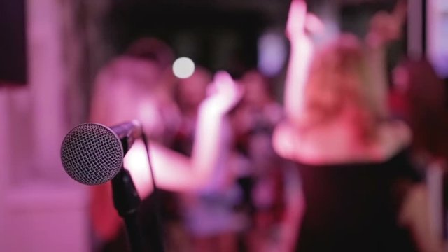 Group of people dancing on the background of the microphone