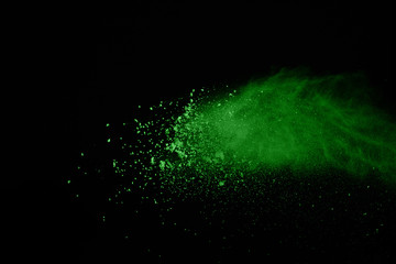 Green powder explosion isolate on black background. Colored cloud. Colorful dust explode. Paint...