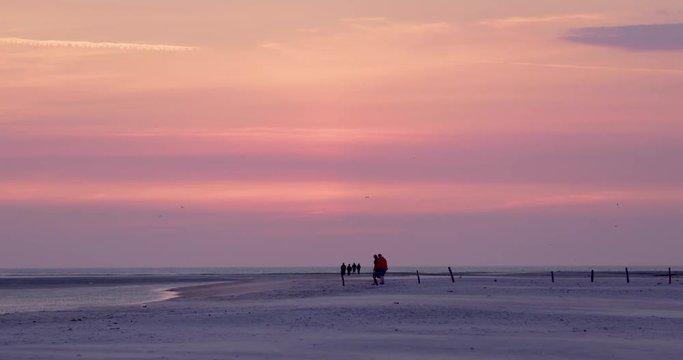 Gold hour sunset in Denmark Scandinavia Europe on beach with people walking