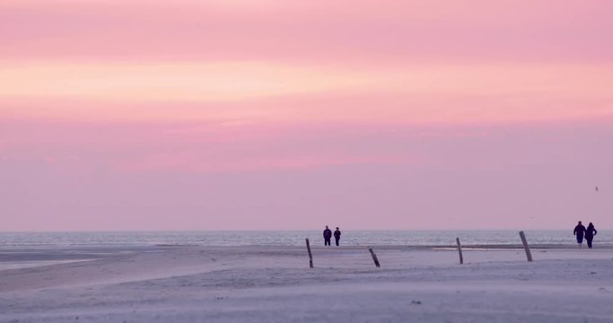Gold hour sunset in Denmark Scandinavia Europe on beach with people walking