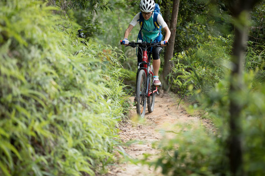 woman cyclist riding mountain bike on forest  trail