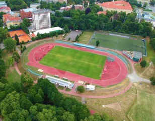 Fototapeta premium City sport center with stadium and court in urban area with park, aerial view