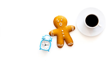 Time for coffee break. Coffee cup near gingerbread man, alarm clock on white background top view copy space