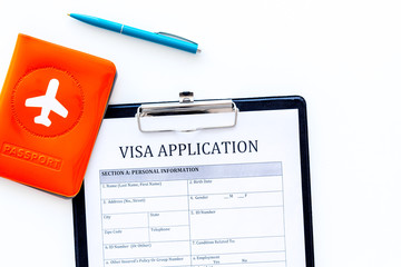 Documents for travel abroad. Visa application form, pen, passport cover with airplane silhouette on...