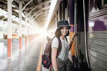 Pretty woman waiting the train at train station for travel in summer. Travel concept.