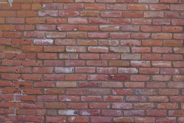 Attractive old weathered traditional clay brick wall in colors of brown, pink, gray, and white