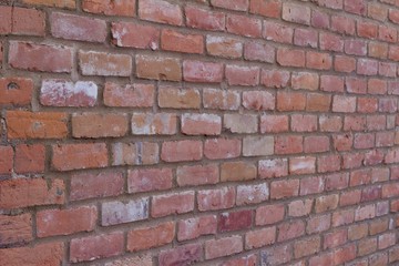 Attractive old weathered traditional clay brick wall in colors of brown, pink, gray, and white