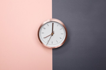 Rose gold clock on pastel pink and grey background. minimal idea business concept.