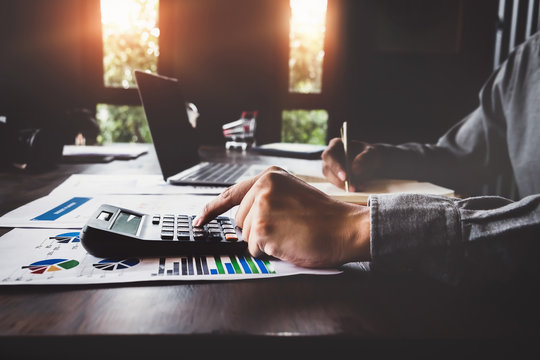 Bookkeeper accounting Concepts, Male use calculator, pen and computer laptop to monitor money saving reports budget to plan before retire. nspector accountant concept.