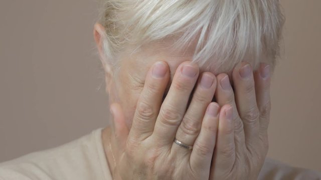 Closeup of aged woman crying.