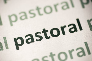 word  pastoral printed on paper macro