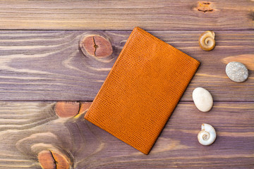 Passport, stone and seashells on a wooden background. Retro style. Place for the inscription. Vacation concept.