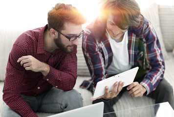 two creative web designers working with a tablet and a laptop.