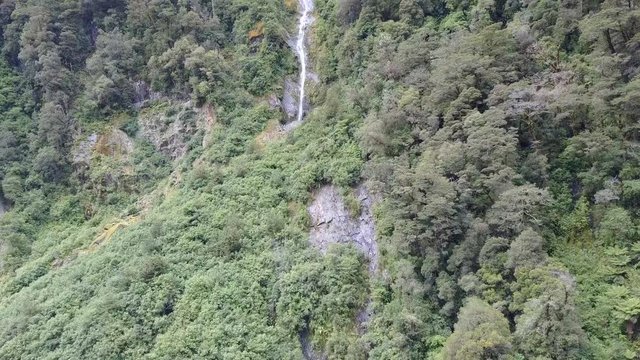 Aerial view of a New Zealand waterfall cascading down the side of a mountain