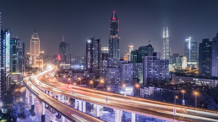 aerial view of buildings and traffic multi-level junction at night in Shanghai city