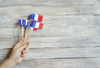 Paper confetti of the national colors of France, white-blue-red on a white wooden background with...