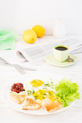 Scrambled eggs, fried bread, ketchup and lettuce leaves on a plate, cup of coffee and newspaper on the table. Ready-to-eat breakfast
