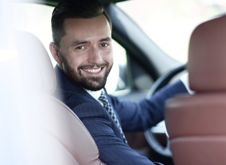 Close-up of a businessman sitting at the wheel of a car