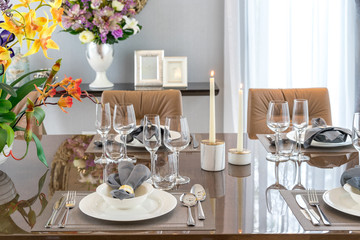 Tables set for meal inside modern home with cozy interior.