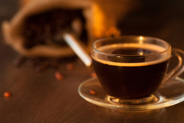 Black roasted arabica coffee beans and cup full of coffee