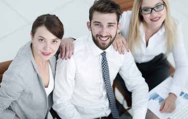 successful business team sitting at table and looking at camera.