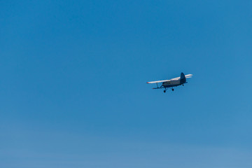 Fototapeta na wymiar Biplane flying in blue sky