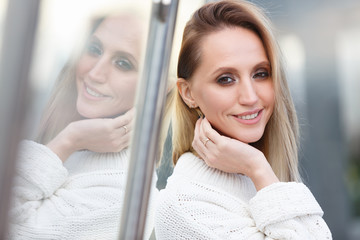 Close-up portrait of a charming successful young woman -psychological coach standing near the glass wall. Concept of success