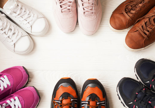 Three pairs of colorful running trainers / exercise shoes on the floor of a sport / shoe shop. Potential copy space on floor.