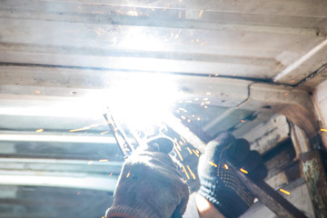 Worker welding the steel part by manual