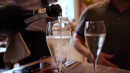 Pouring champagne in a glass in slow motion - Powered by Adobe