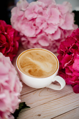 Cup of cappuccino and flowers.