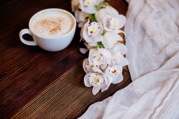 Fototapeta na wymiar Cup of cappuccino and flowers.