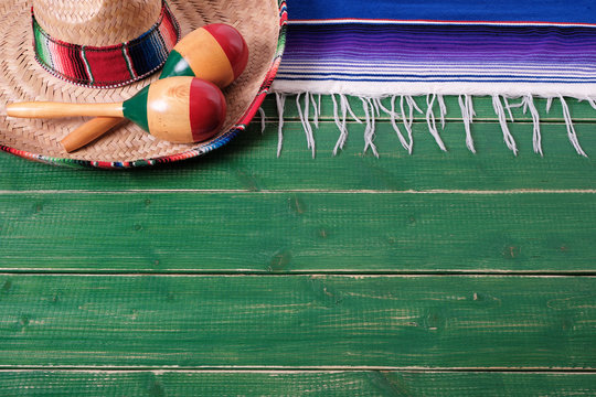 Mexico cinco de mayo fiesta carnival traditional green wood background border mexican sombrero maracas serape rug or blanket photo