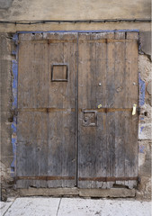 old brown grungy weathered doors with rusty hinges and blue paint around the edges