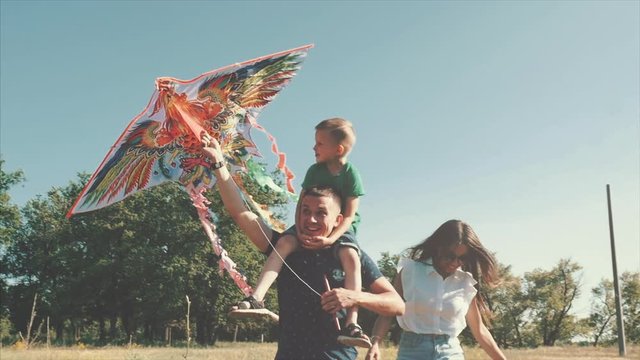 Happy family, mom, dad and son are walking in nature, launching an air snake. Stock footage.
