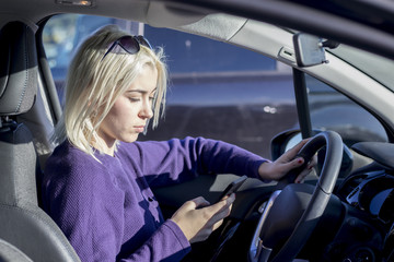 Beautiful woman is using a smart phone inside the car