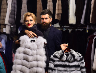 Man and woman with coats in fur shop.