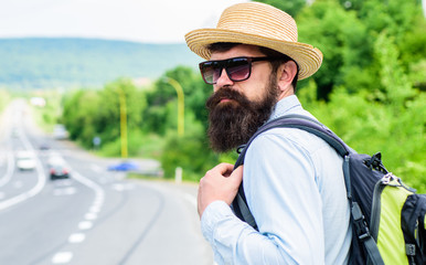 Travel alone. Hitchhiking means transportation gained asking strangers for ride in their car. Hitchhiker travel alone try stop transport to get to destination. Man at edge of highway wait transport