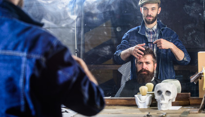 Man with beard and mustache in hairdressers chair in front of mirror background. Reflexion of...