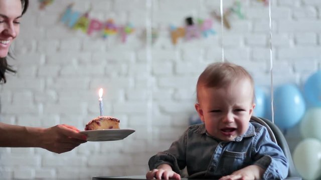 Portrait of cute upset crying baby boy celebrating his first birthday