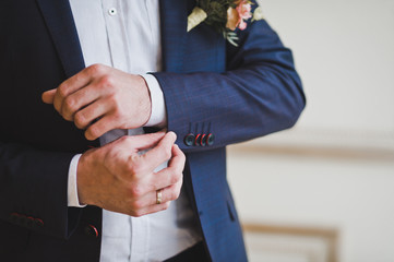 A mans hand corrects the lapel of the suit 1491.